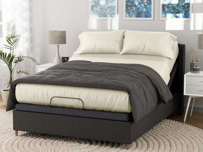 Image of a dressed bed on an adjustable base with Ivory Deluxe Cool Stretch Sheets and a dark gray comforter on top