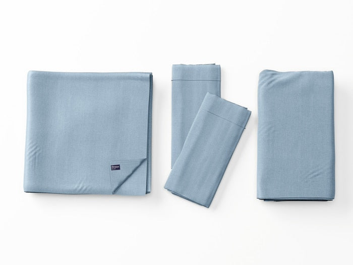 Image of Light Blue Deluxe Cool Stretch Sheet Set left to right: Folded flat sheet with folded corner, two folded pillowcases, folded fitted sheet