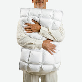 Image of a man softly smiling and hugging the SoftCell® Lite Pillow
