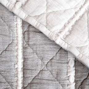 Close-up image showcasing the reversible aspect of the gray and white Heritage Quilt