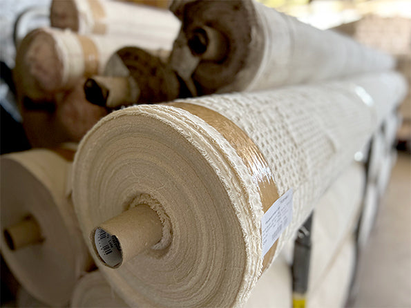 Image showcasing rolls of quilted fabric in a warehouse