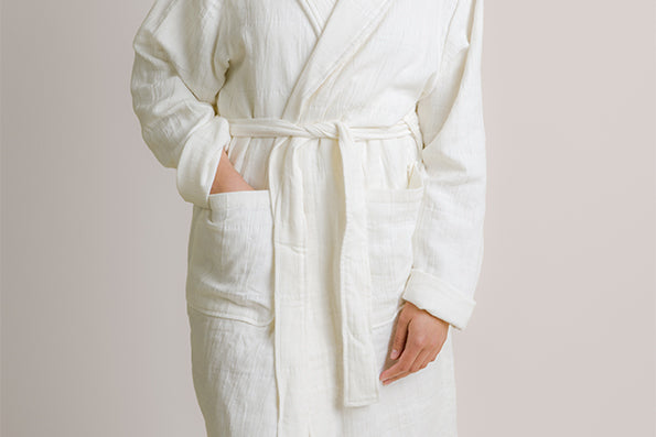 Image of person wearing the white Featherweight Robe with their hand showcasing the deep pockets
