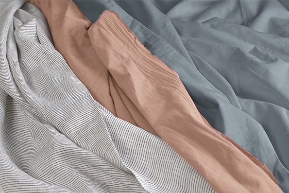 Image of all three Dr. Weil sheet options. From left to right: Pinstripe Relaxed Hemp Sheets, Ochre Garment Washed Percale Sheets, Stone Gray Blended Linen Sheets