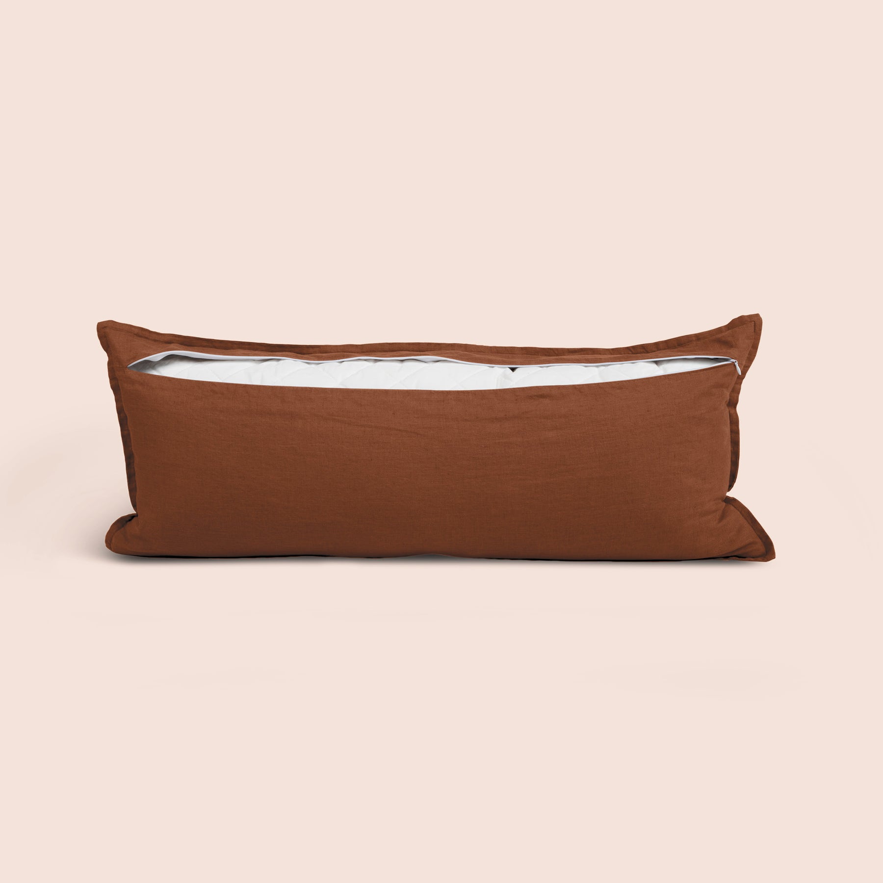 Image of the back of the Cacao Blended Linen Lumbar Pillow Cover on a lumbar pillow with the back zipper open on a light pink background