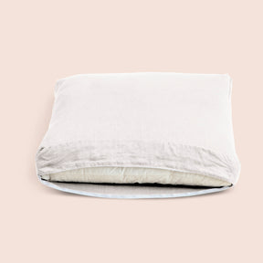 Image of White Blended Linen Meditation Cushion Cover showcasing an open zipper with a meditation cushion inside on a light pink background 