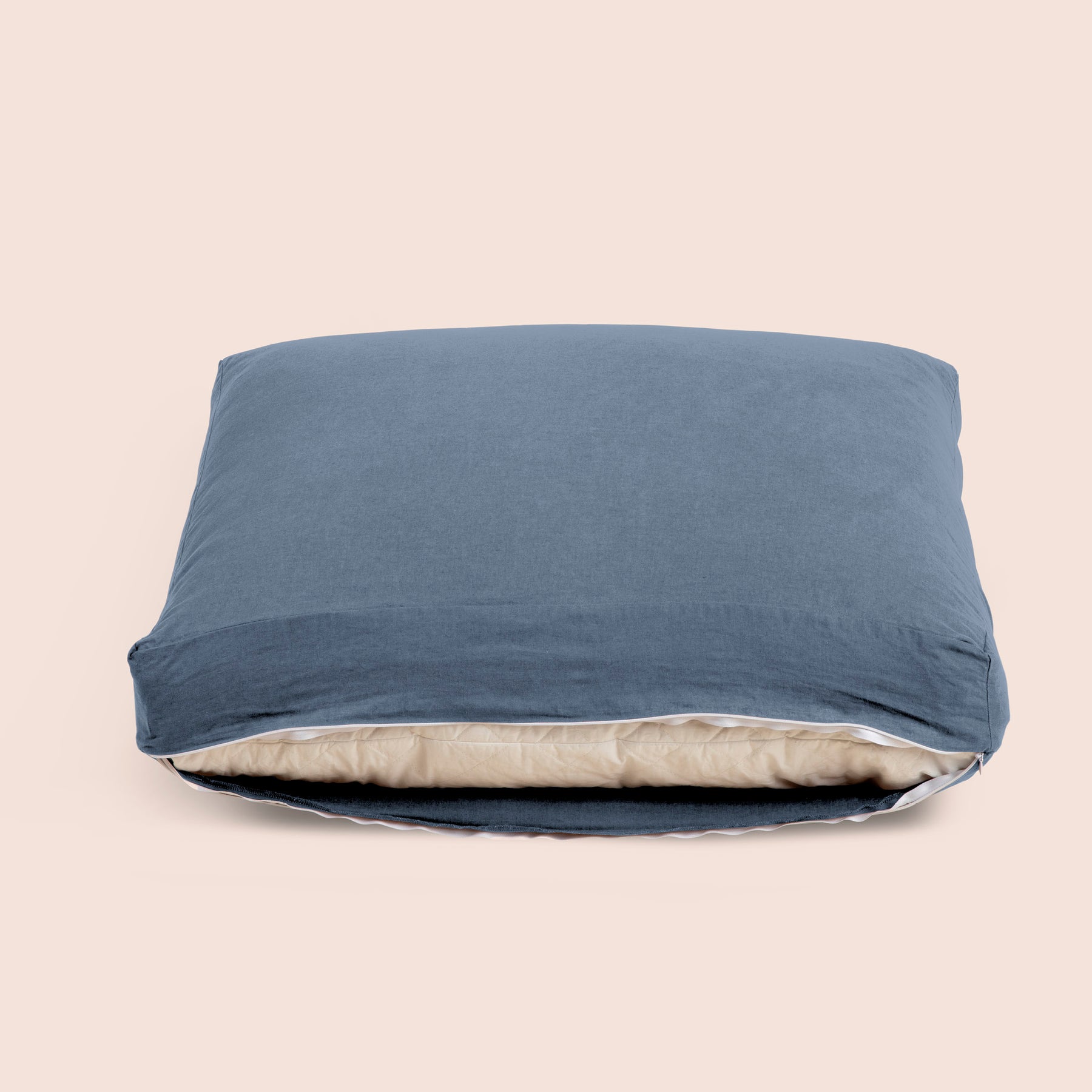 Image of Catalina Blue Blended Linen Meditation Cushion Cover showcasing an open zipper with a meditation cushion inside on a light pink background 