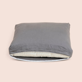 Image of Stone Gray Blended Linen Meditation Cushion Cover showcasing an open zipper with a meditation cushion inside on a light pink background 