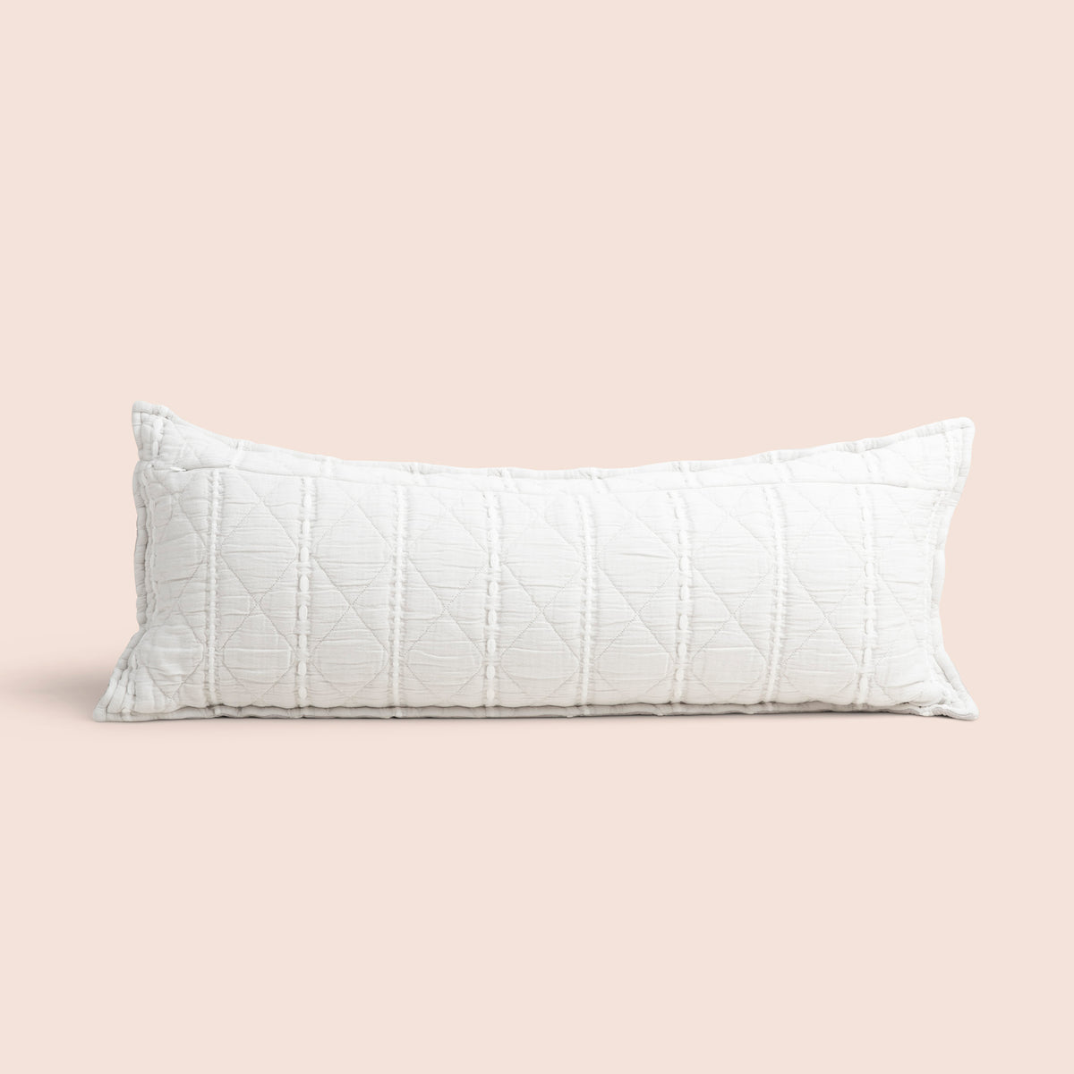 Image of the all-white reversible side of the Heritage Lumbar Pillow Cover on a lumbar pillow with a light pink background