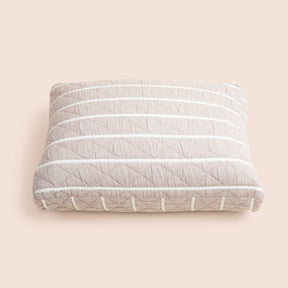Image of the gray and white striped side of the Heritage Meditation Cushion Cover on a meditation cushion with a light pink background