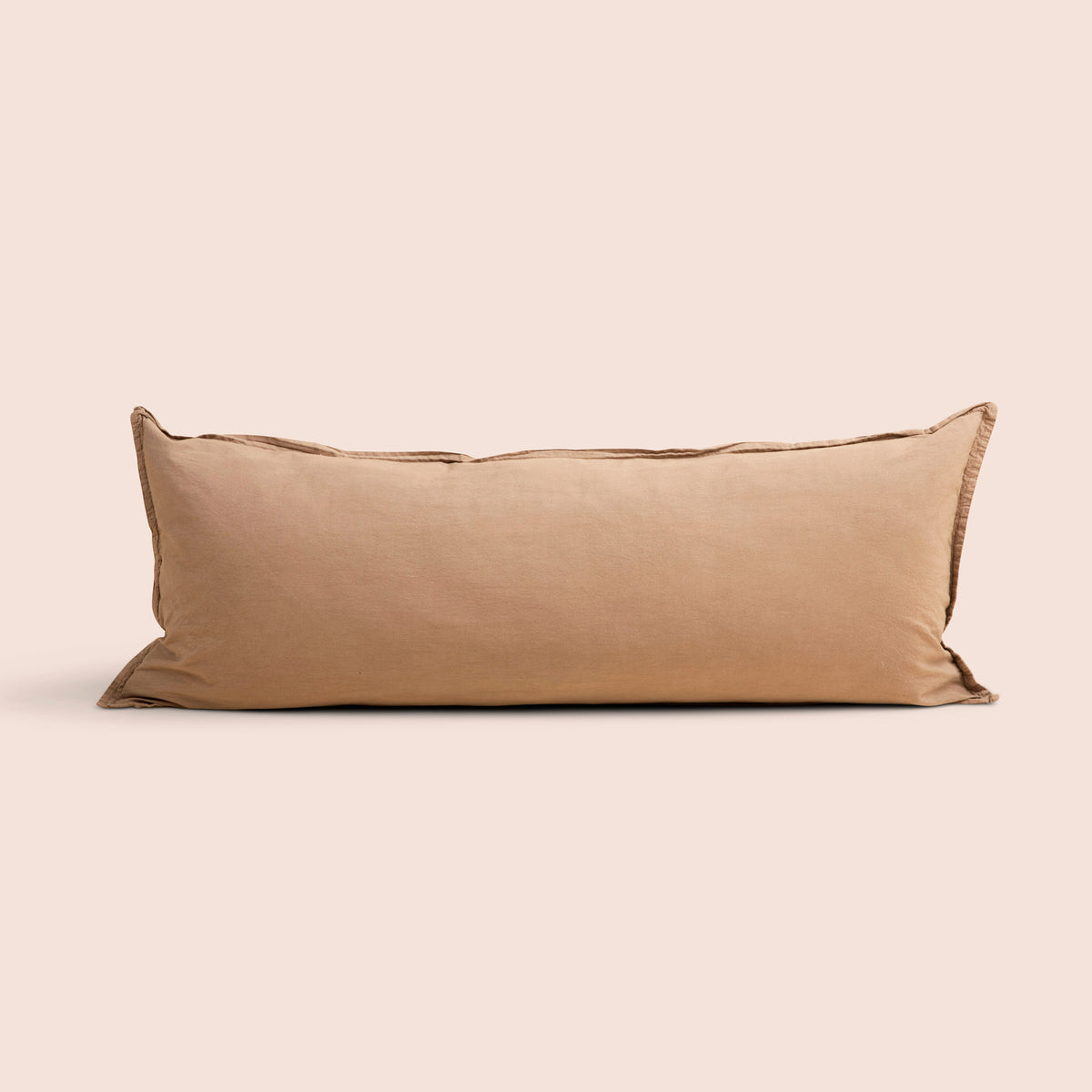 Image of Ochre Garment Washed Percale Lumbar Pillow Cover on a lumbar pillow with a light pink background