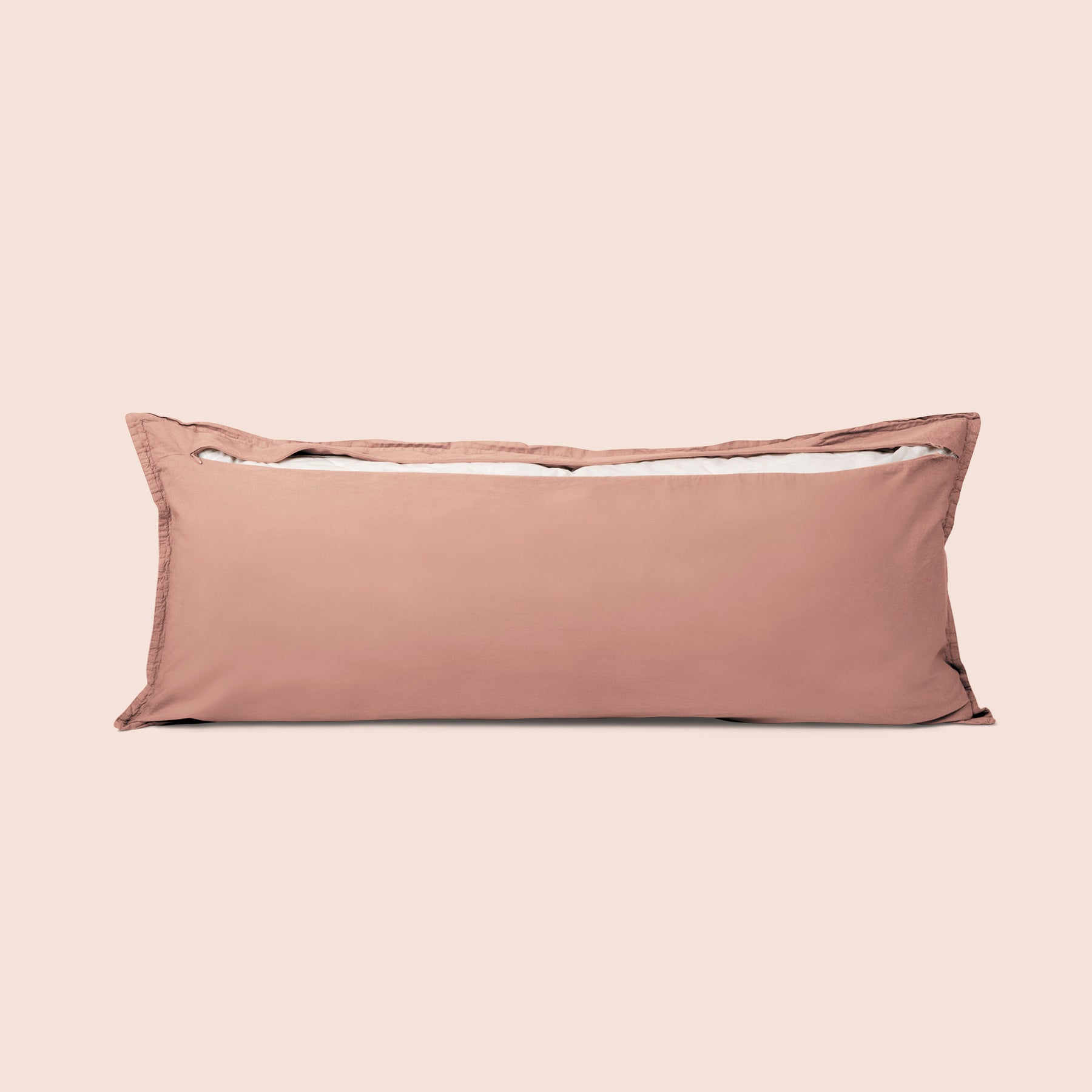 Image of the back of the Pink Sandstone Garment Washed Percale Lumbar Pillow Cover on a lumbar pillow with the back zipper open on a light pink background