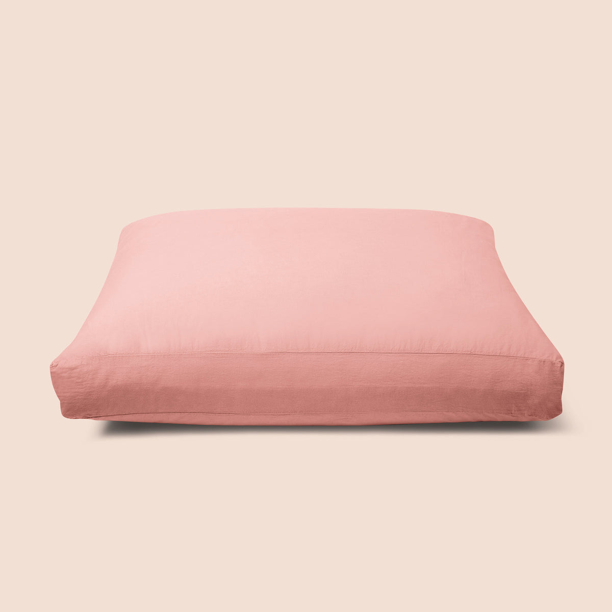 Image of Pink Sandstone Garment Washed Percale Meditation Cushion Cover on a meditation cushion with a light pink background