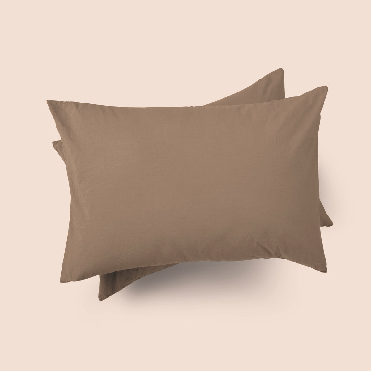 Image of the top of the Desert Sand Garment Washed Percale Pillow Sham on two pillows stacked on top of one another with a light pink background