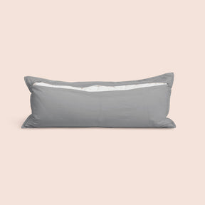 Image of the back of the Stone Gray Relaxed Hemp Lumbar Pillow Cover on a lumbar pillow with the back zipper open on a light pink background