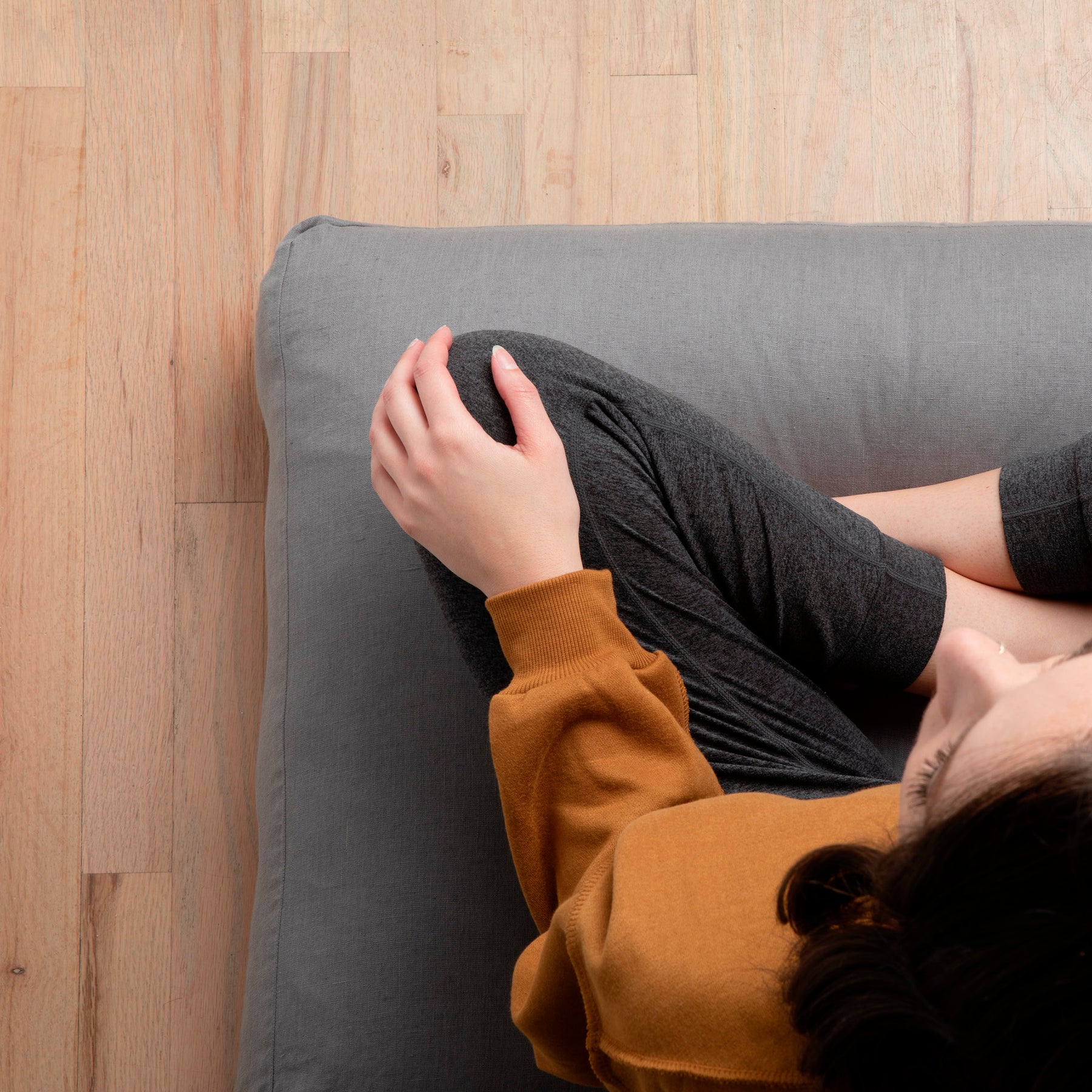 Image of woman sitting cross-legged on a meditation cushion with the Stone Gray Relaxed Hemp Meditation Cushion Cover
