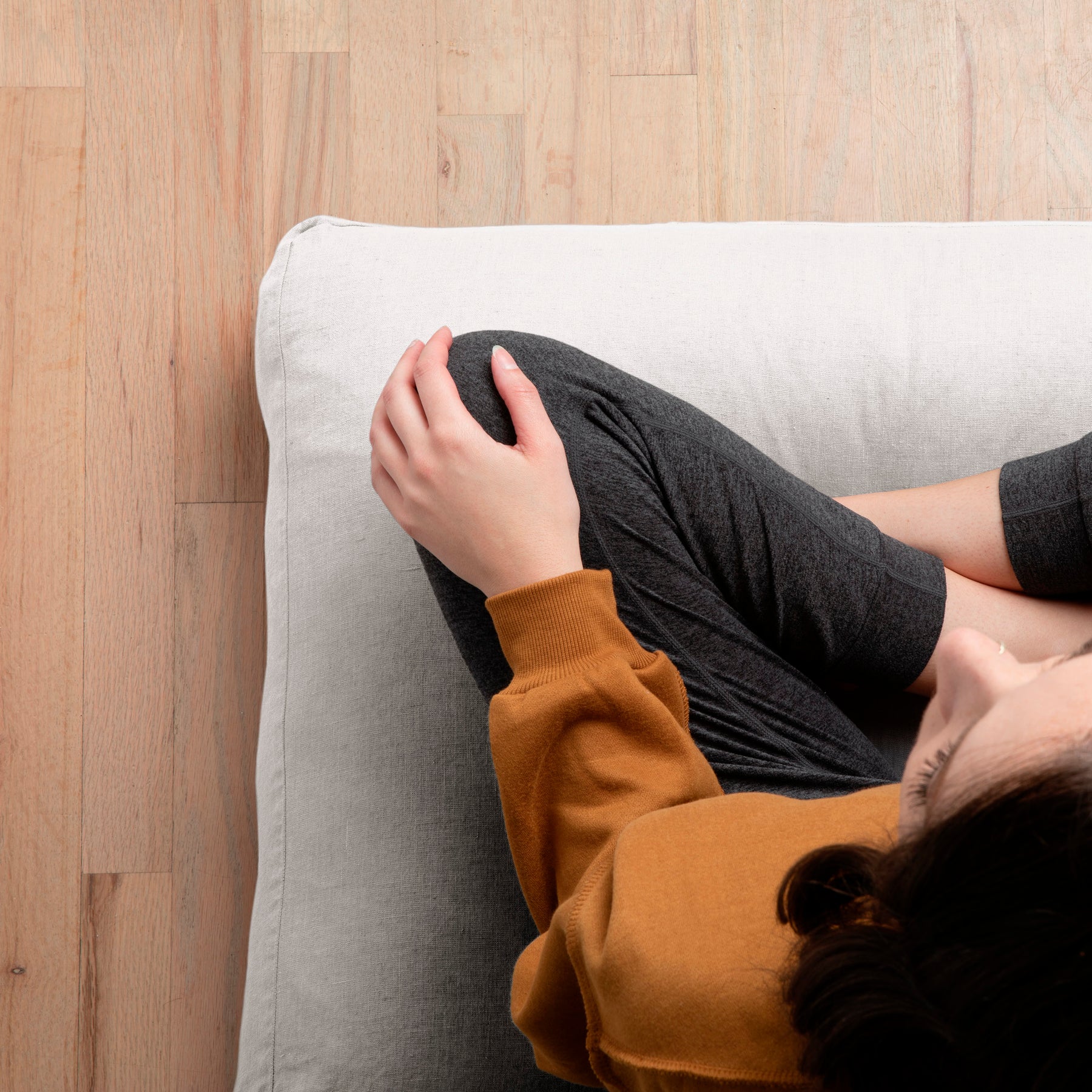 Image of woman sitting cross-legged on a meditation cushion with the White Relaxed Hemp Meditation Cushion Cover