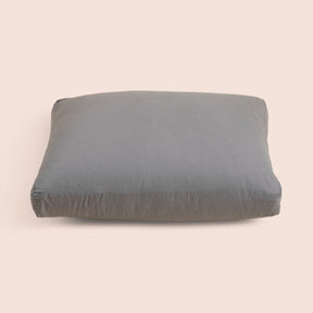 Image of the Stone Gray Relaxed Hemp Meditation Cushion Cover on a meditation cushion with a light pink background