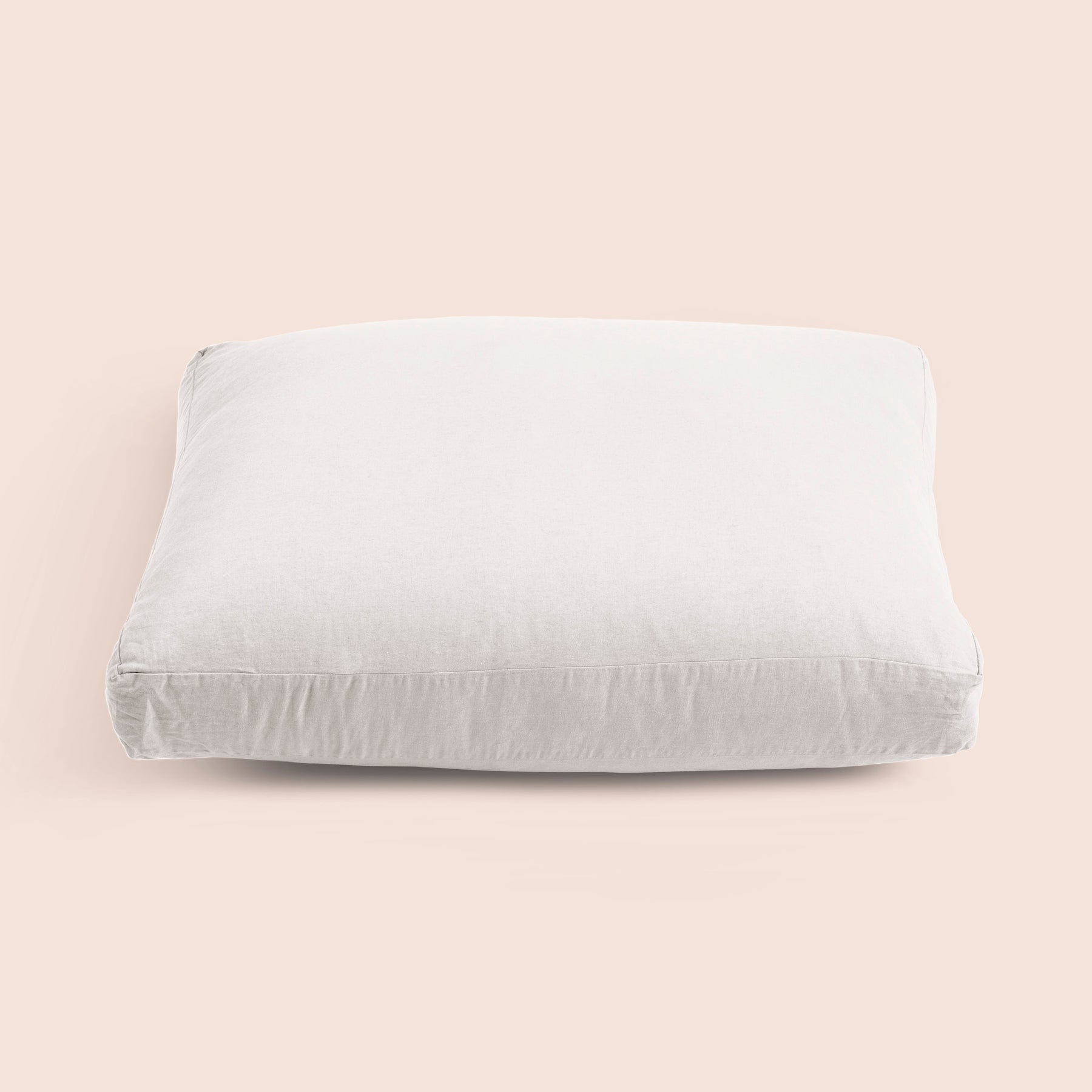 Image of the White Relaxed Hemp Meditation Cushion Cover on a meditation cushion with a light pink background