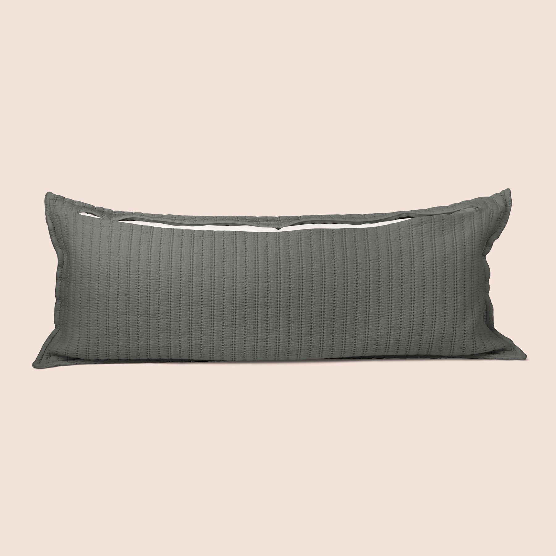 Image of the back of the Agave Ridgeback Lumbar Pillow Cover on a lumbar pillow with the back zipper open on a light pink background
