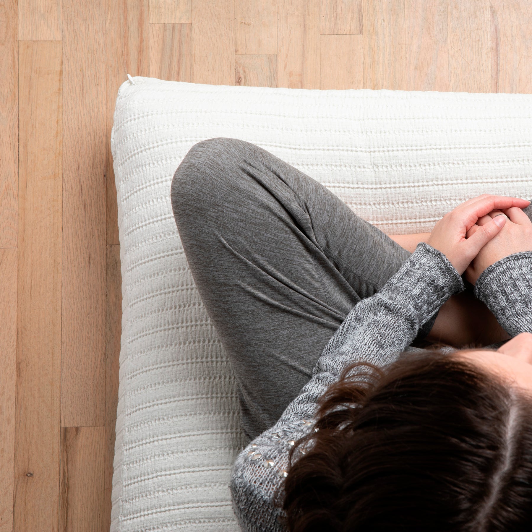 Image of woman sitting cross-legged on a meditation cushion with the Ecru Ridgeback Meditation Cushion Cover 