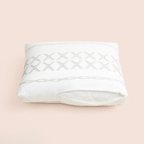 Image of the Sonoran Meditation Cushion Cover showcasing a slightly opened zipper with a meditation cushion inside on a light pink background 