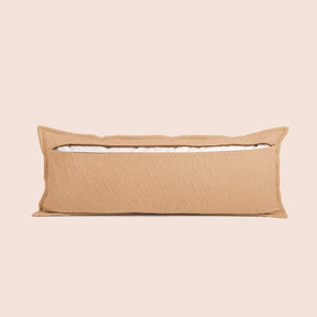 Image of the back of the Ochre Wave Lumbar Pillow Cover on a lumbar pillow with the back zipper open on a light pink background