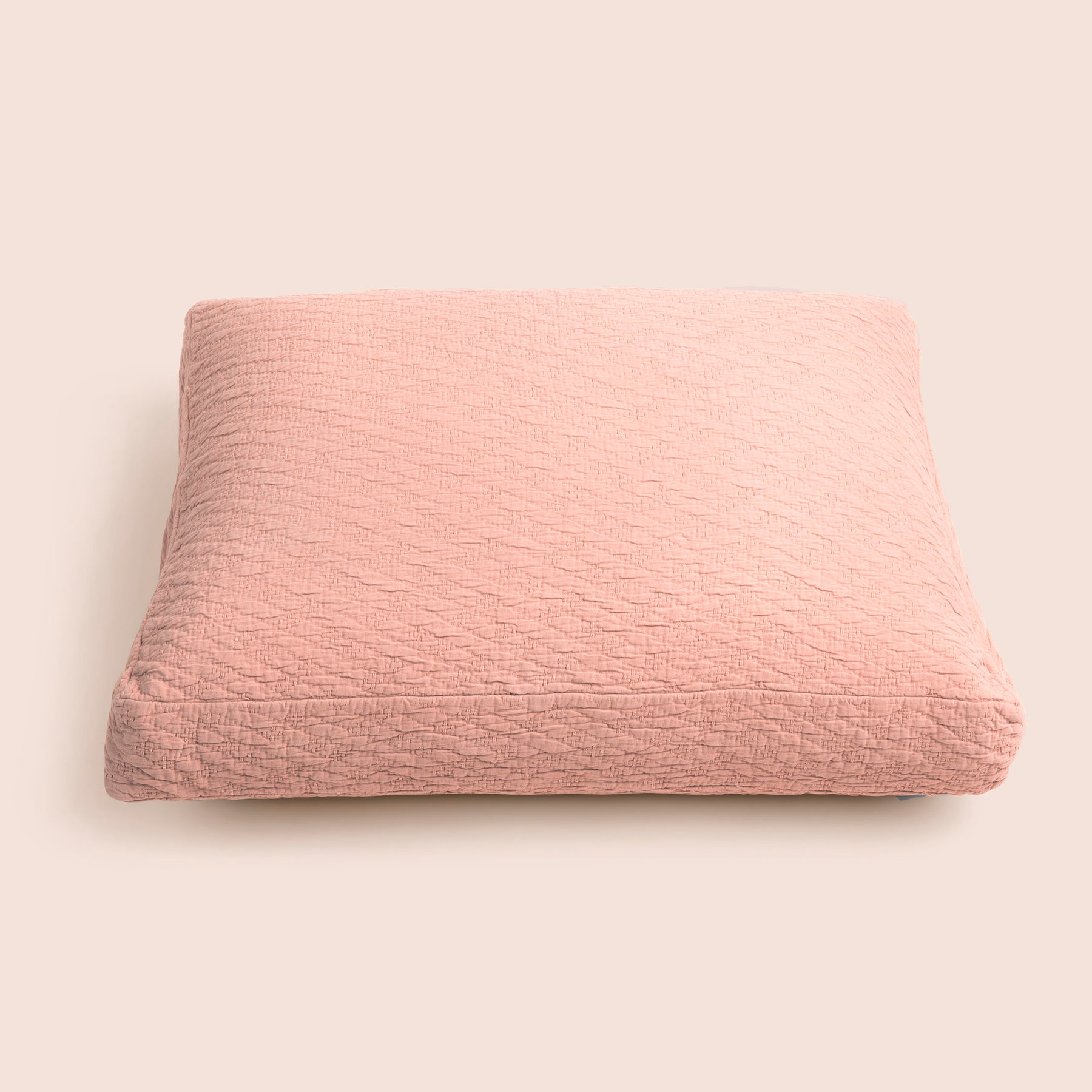 Image of the Pink Sandstone Wave Meditation Cushion Cover on a meditation cushion with a light pink background