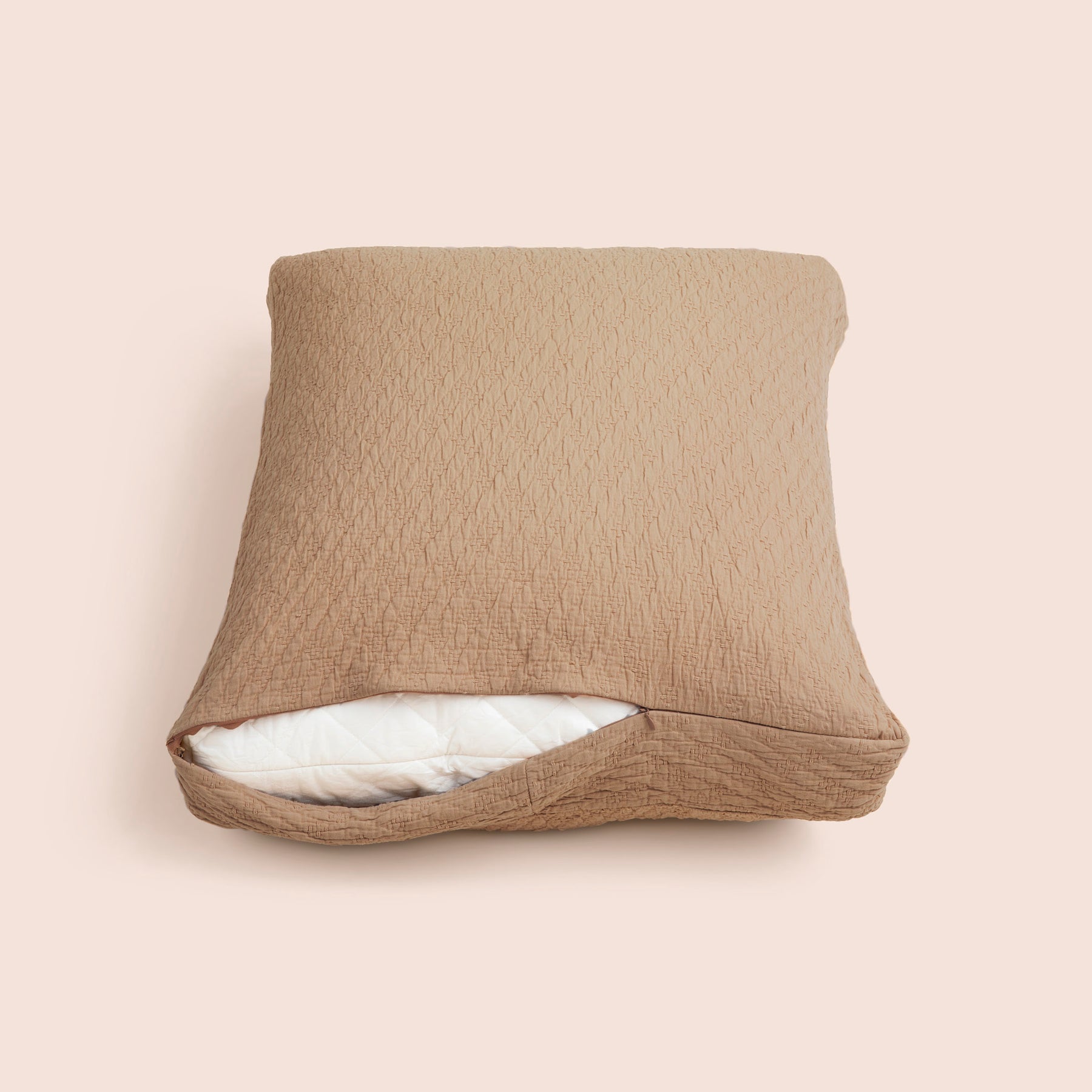Image of the Ochre Wave Meditation Cushion Cover showcasing a slightly opened zipper with a meditation cushion inside on a light pink background 