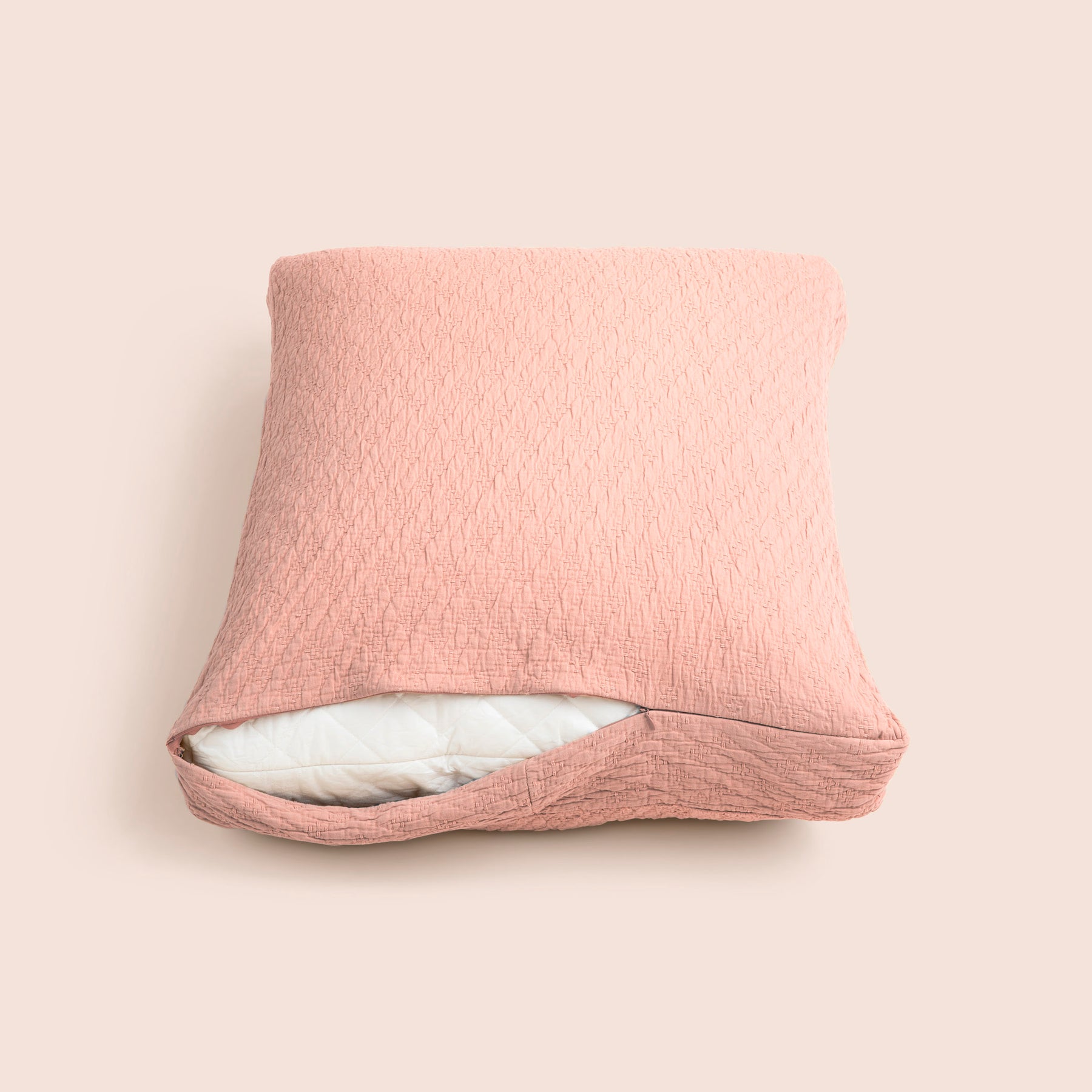 Image of the Pink Sandstone Wave Meditation Cushion Cover showcasing a slightly opened zipper with a meditation cushion inside on a light pink background 