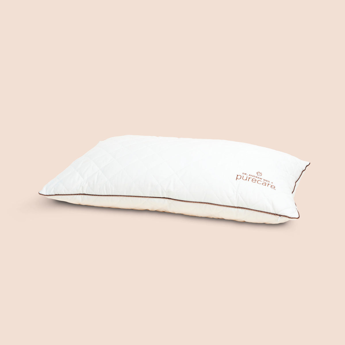 Image of All Seasons Wool Pillow on light pink background with Dr. Andrew Weil + Purecare logo in bottom right corner of pillow