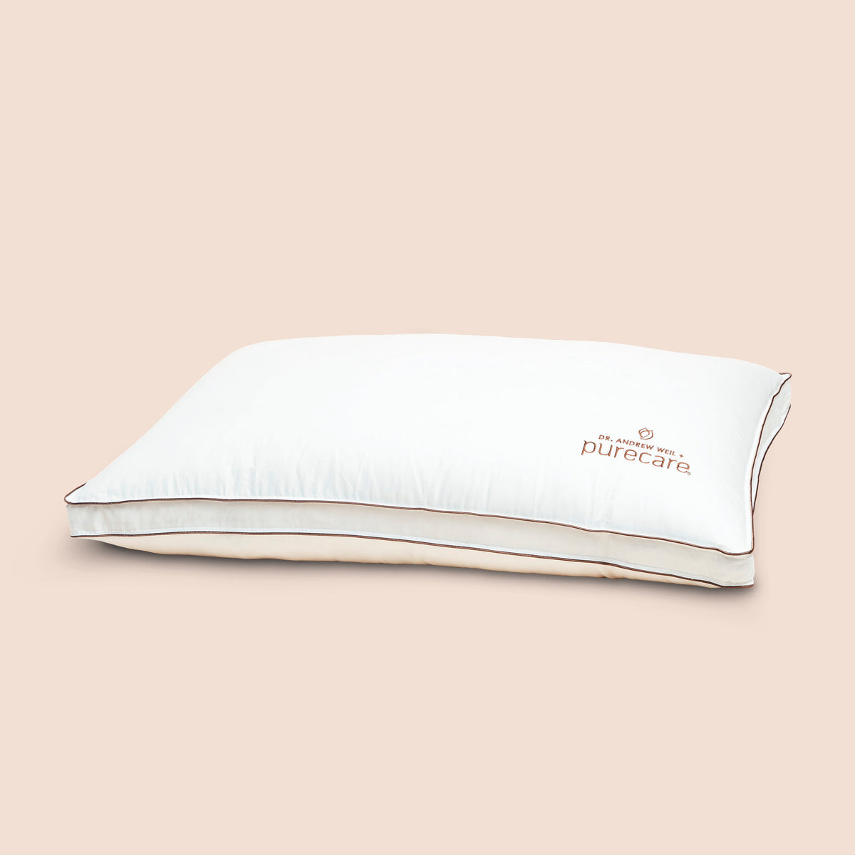 Image of Chambered Down Pillow on light pink background with Dr. Andrew Weil + Purecare logo in bottom right corner of pillow