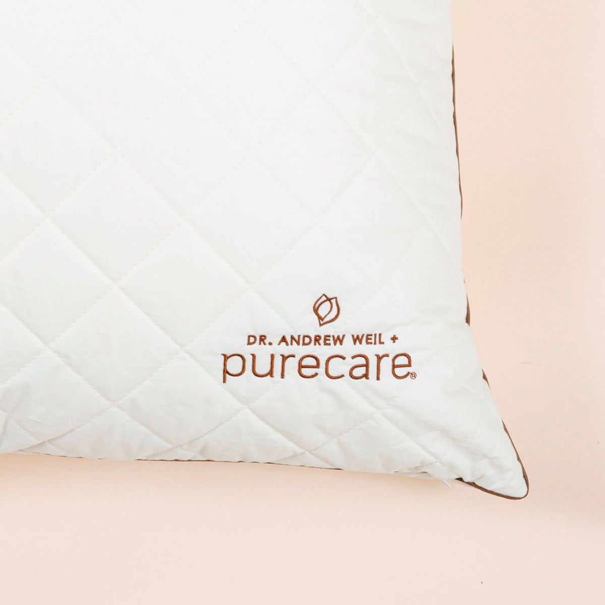 Close-up image of the Dr. Andrew Weil + Purecare logo on bottom right corner of Euro Pillow Insert