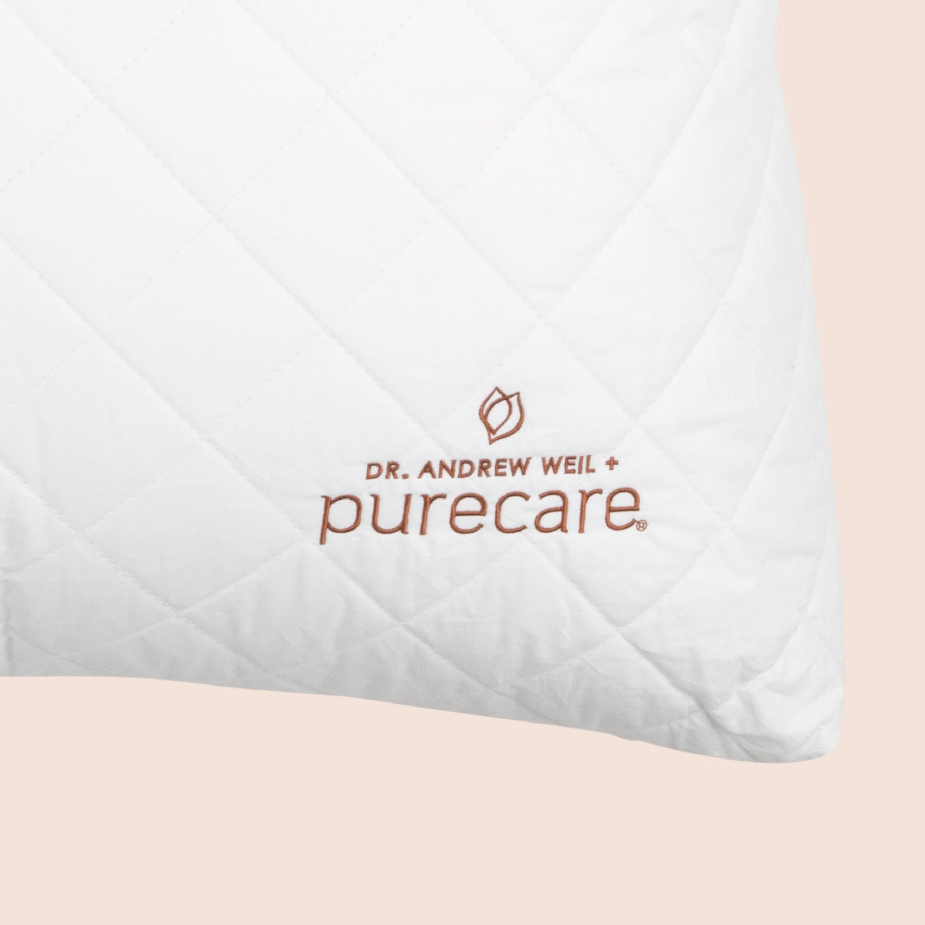 Close-up image of the Dr. Andrew Weil + Purecare logo on bottom right corner of cushion