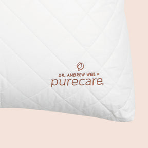 Close-up image of the Dr. Andrew Weil + Purecare logo on bottom right corner of cushion