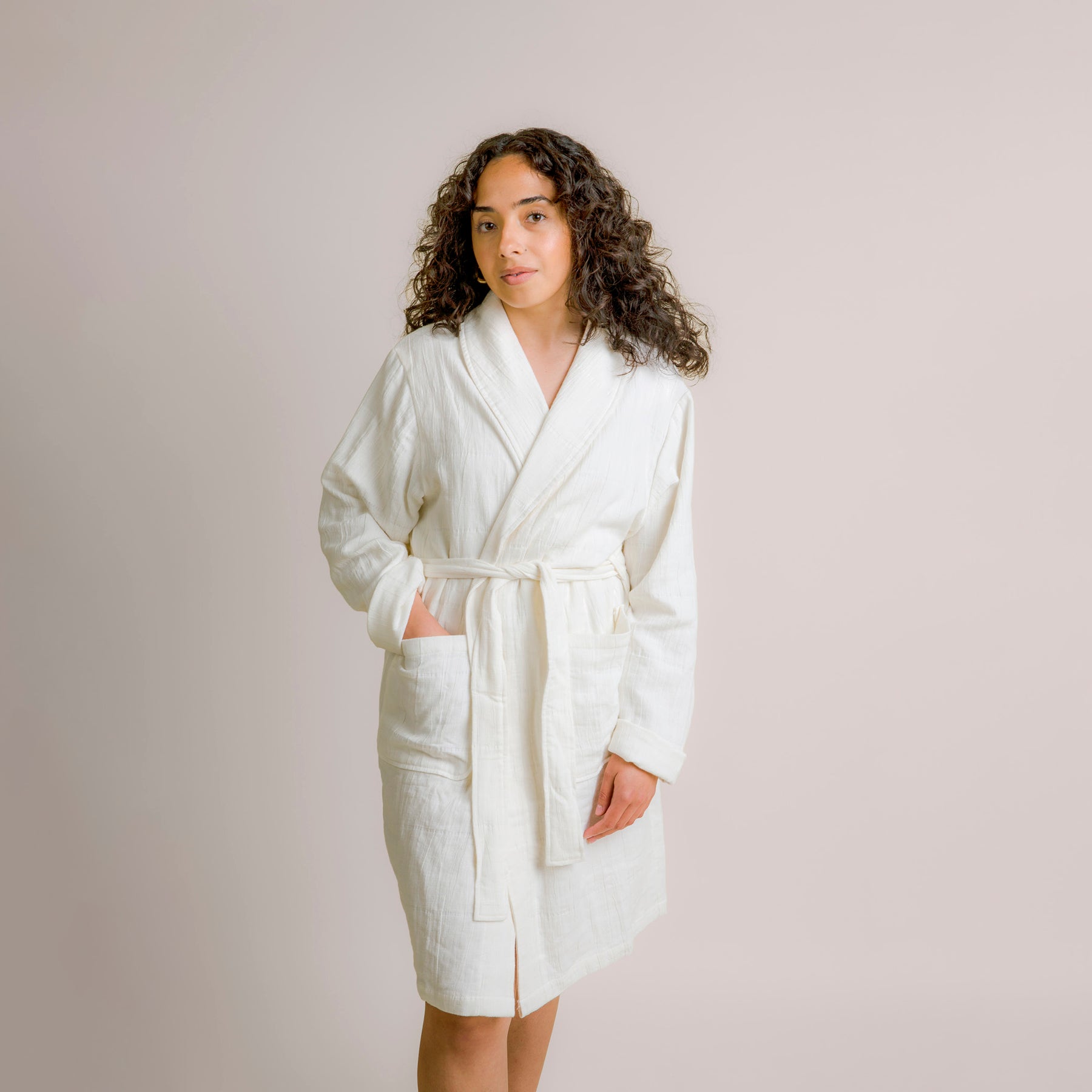 Image of woman wearing a white Featherweight Robe with her hand showcasing the deep pocket