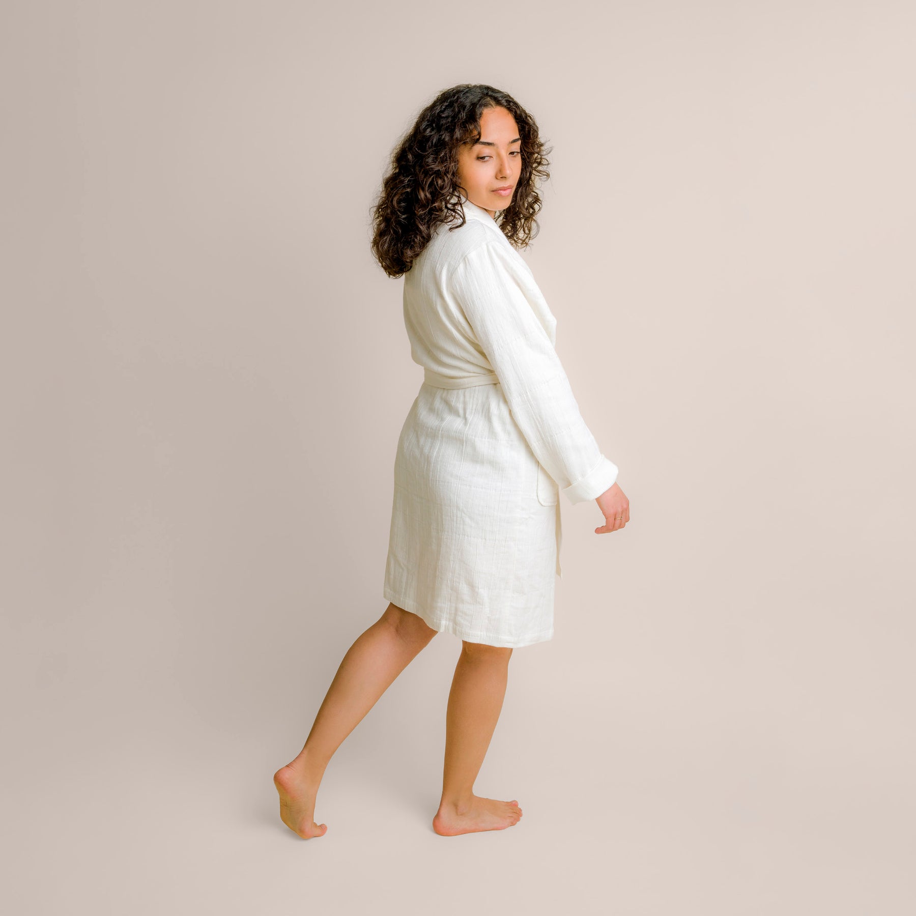 Image of woman turning around to showcase the back of the white Featherweight Robe