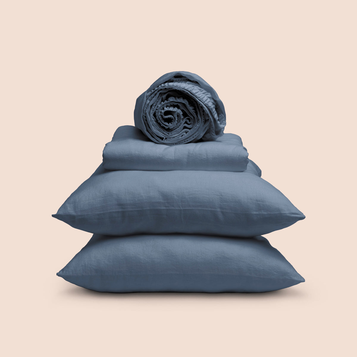 Image showcasing entire Catalina Blue Blended Linen Sheet Set on a light pink background. Set features a rolled-up fitted sheet on top, a neatly folded flat sheet, and two stacked pillowcases. 