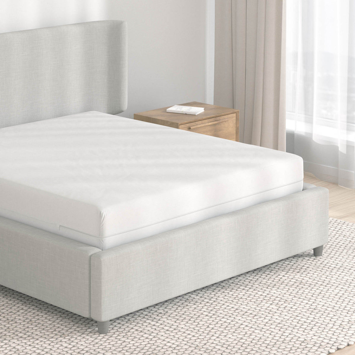 Image of a light, neutral-colored bedroom with just an encasement mattress protector on the bed