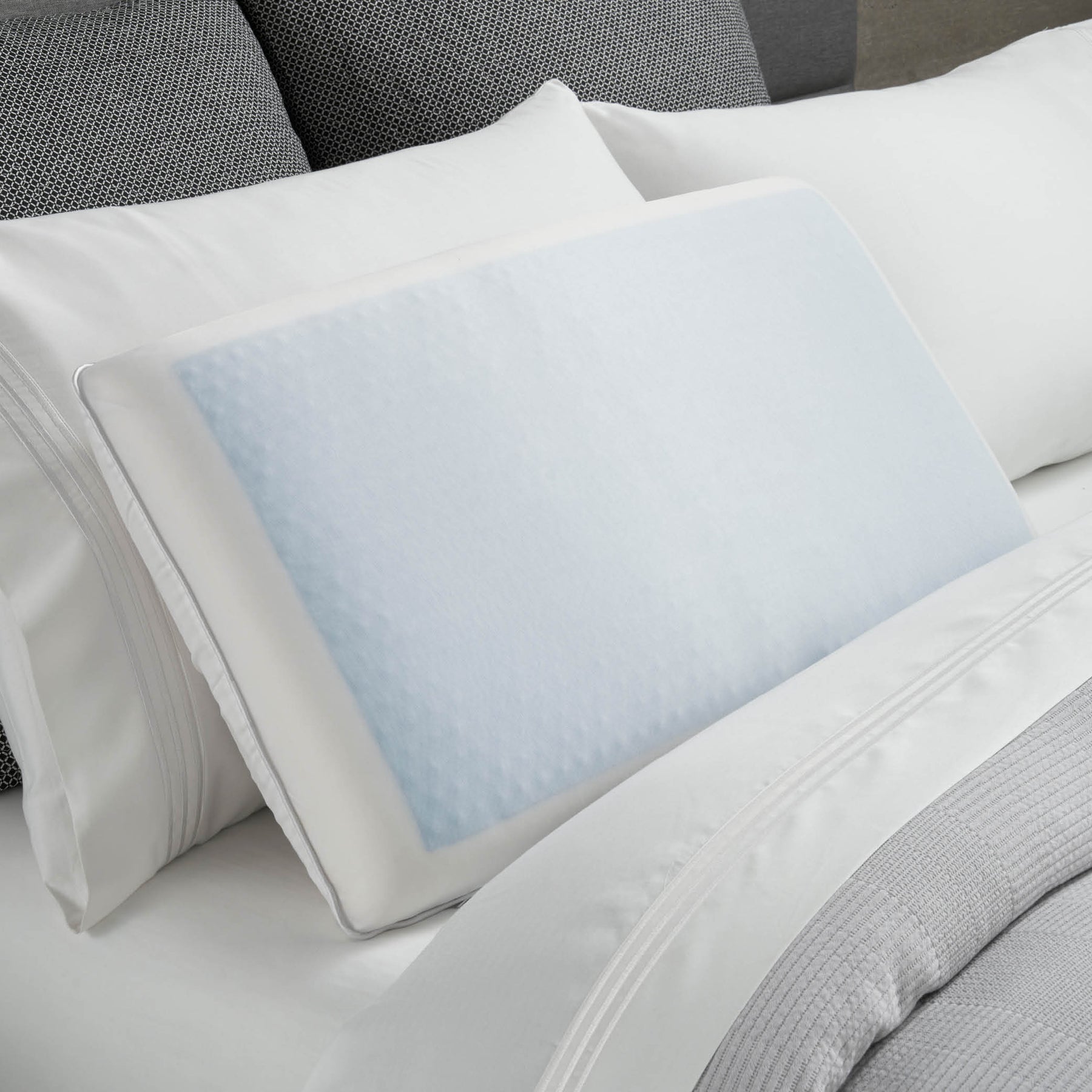 Image of the Cooling Replenish Pillow on a gray and white bed with the cool gel side facing up