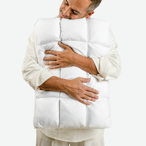 Image of a man smiling with his eyes closed and head resting on the Cooling SoftCell® Chill Pillow he's holding against him 