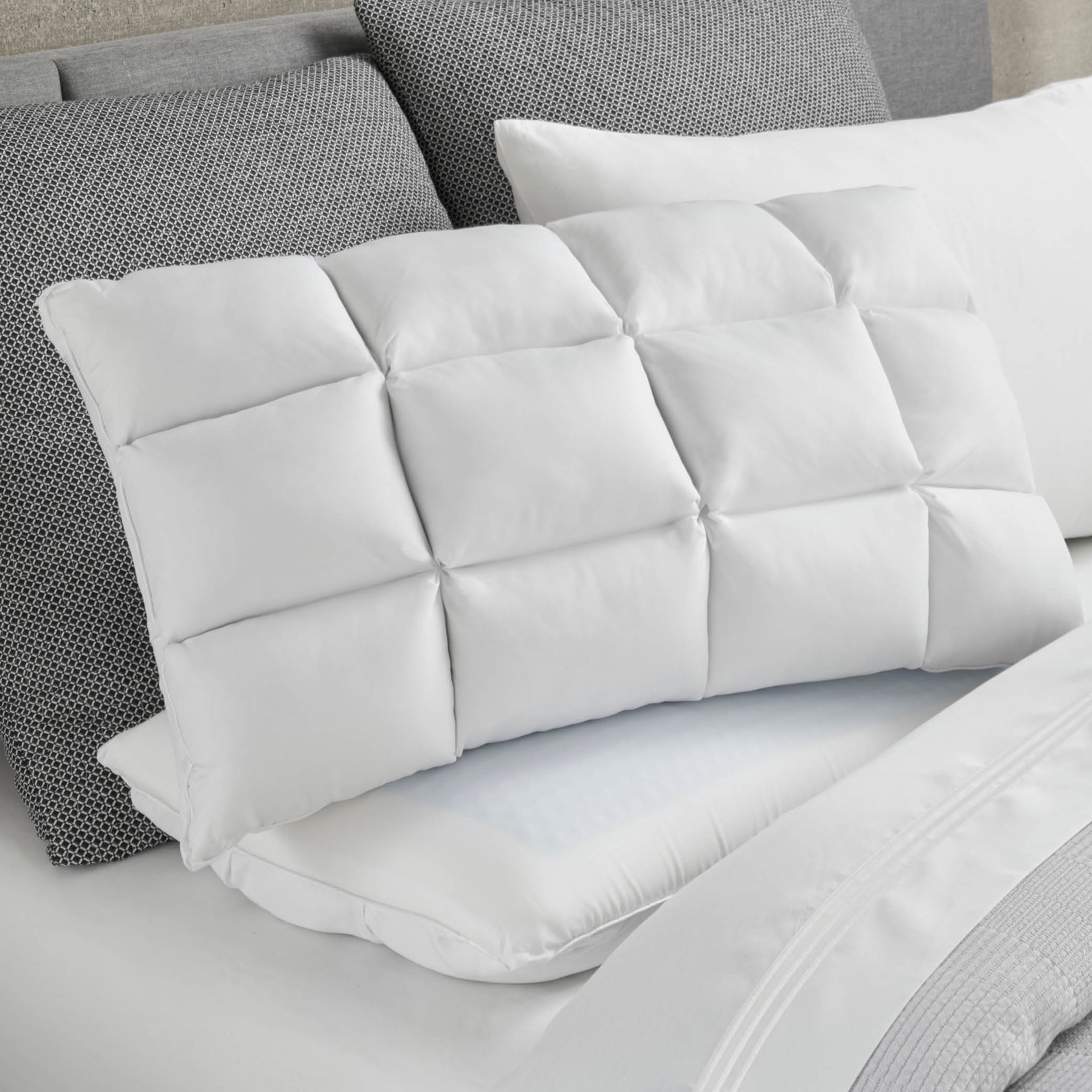 Image of a Cooling SoftCell® Chill Pillow on a gray and white bed with the SoftCell side facing forward