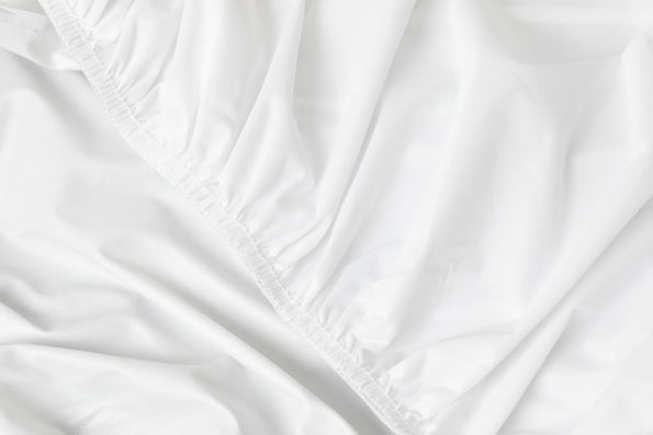 Close-up image of the elastic band on a white mattress protector