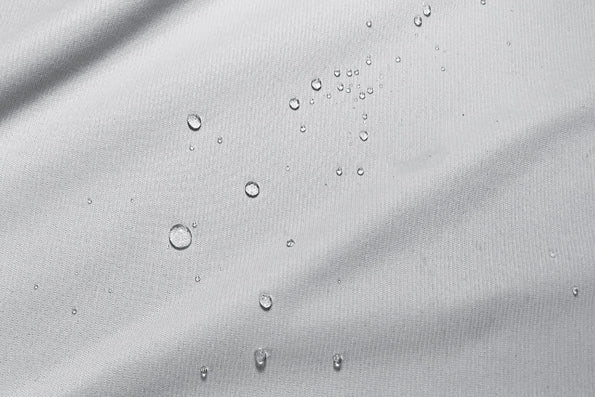 Close-up image of white protector fabric with water droplets across the middle