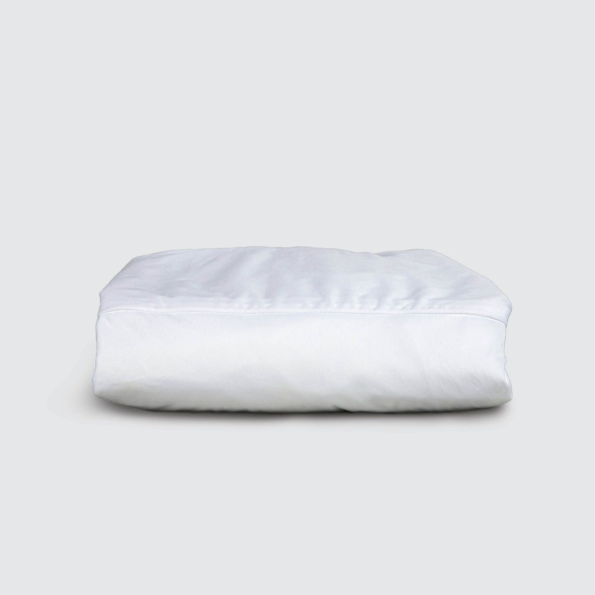 Image of a folded white mattress protector on a white background