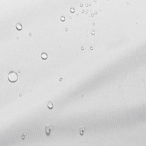 Close-up image of the white pillow protector fabric with water droplets down the left side