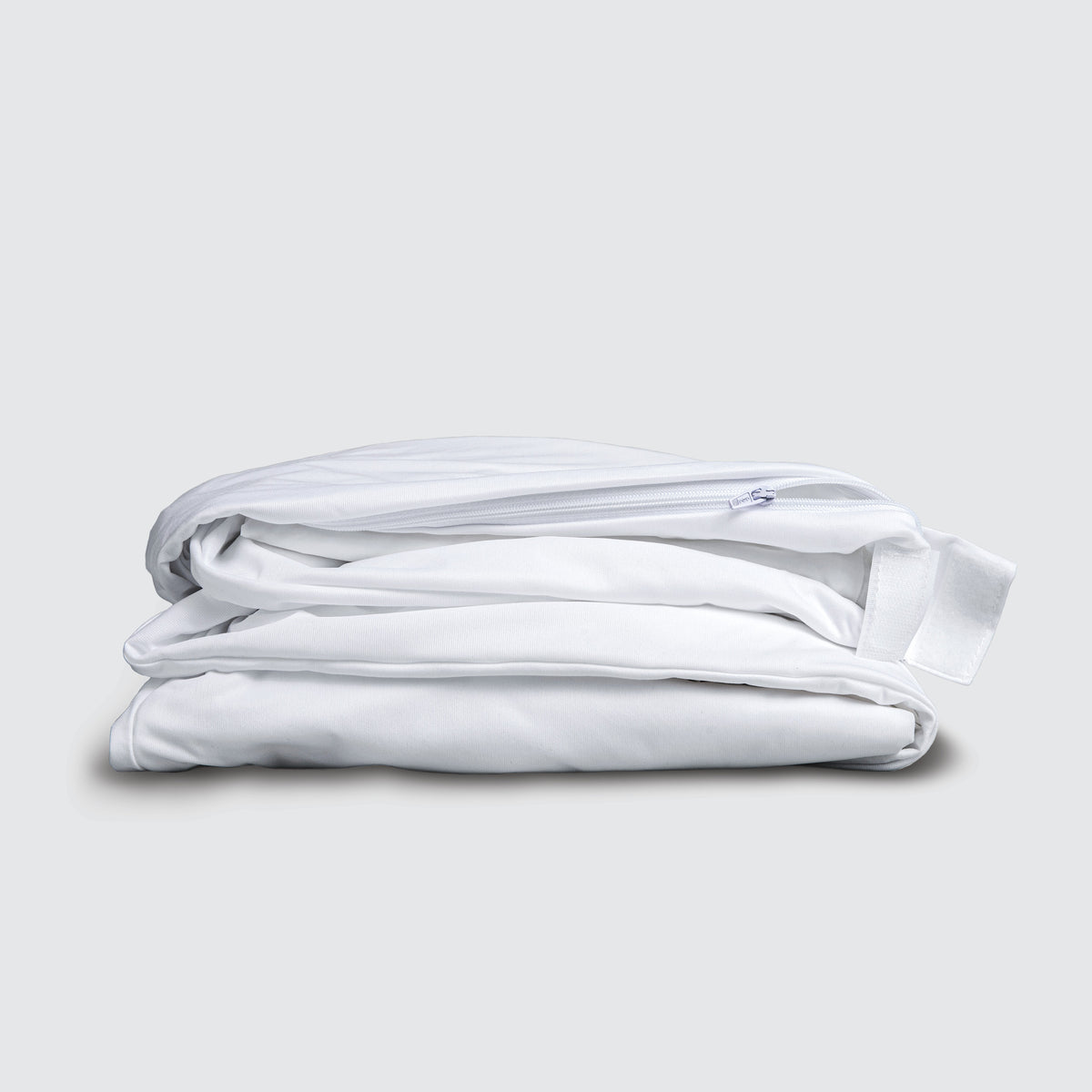 Image of a folded white mattress encasement on a white background