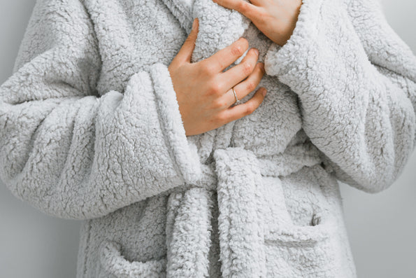 Close-up image of the mid-section of the Sunday Morning Robe on a woman with her hands on the collar