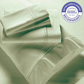 Image showcasing entire Sage Bamboo Rayon Sheet Set. The image includes: a fitted sheet on the bed, a pillowcase on a pillow, a neatly folded flat sheet, and two neatly folded pillowcases. There is a sticker in the top right corner that reads: Better Homes & Gardens Recommends 