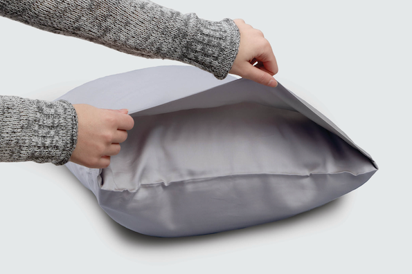 Image of two hands holding open the side of a Light Blue Soft Touch Pillowcase showcasing the enveloping design
