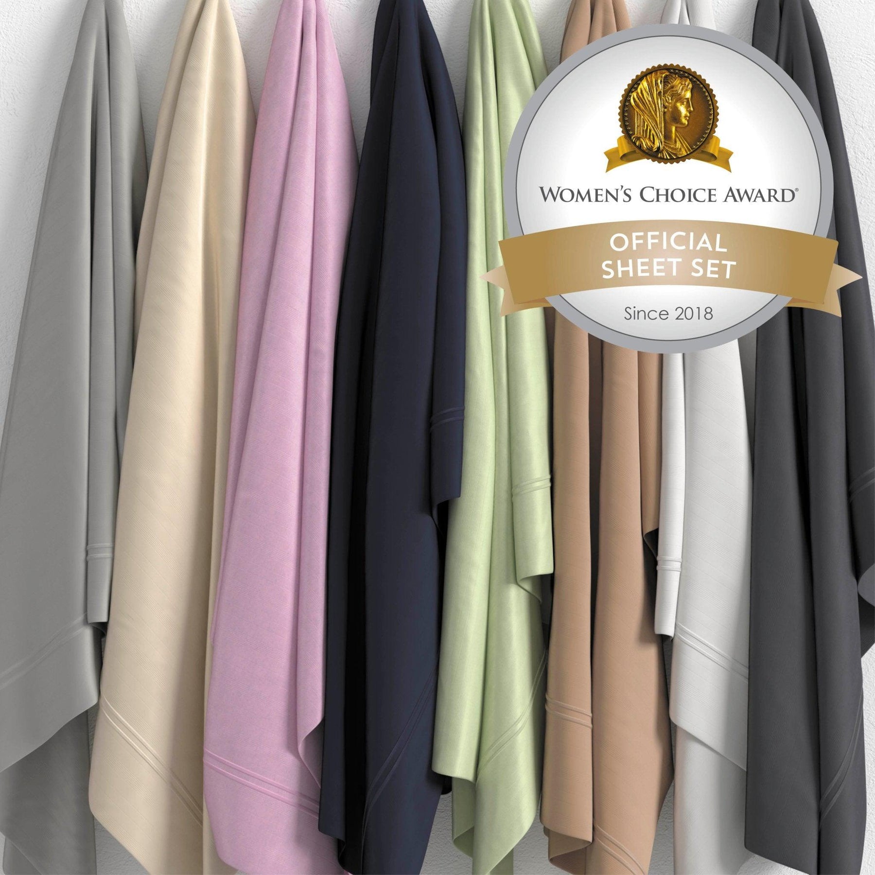 Image of all Bamboo Rayon Sheet colors hanging against a white wall (from left to right): Dover Gray, Ivory, Lilac, Midnight, Sage, Sand, White, Shadow. There's a sticker reading: "Woman's Choice Award Official Sheet Set Since 2018" in the top right corner. 